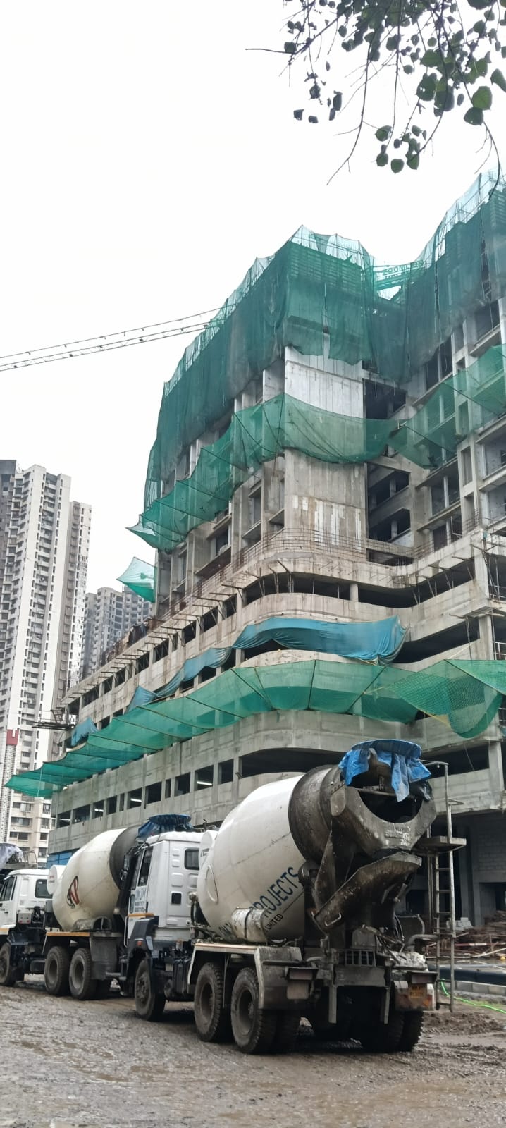High-rise construction site covered with green construction safety nets